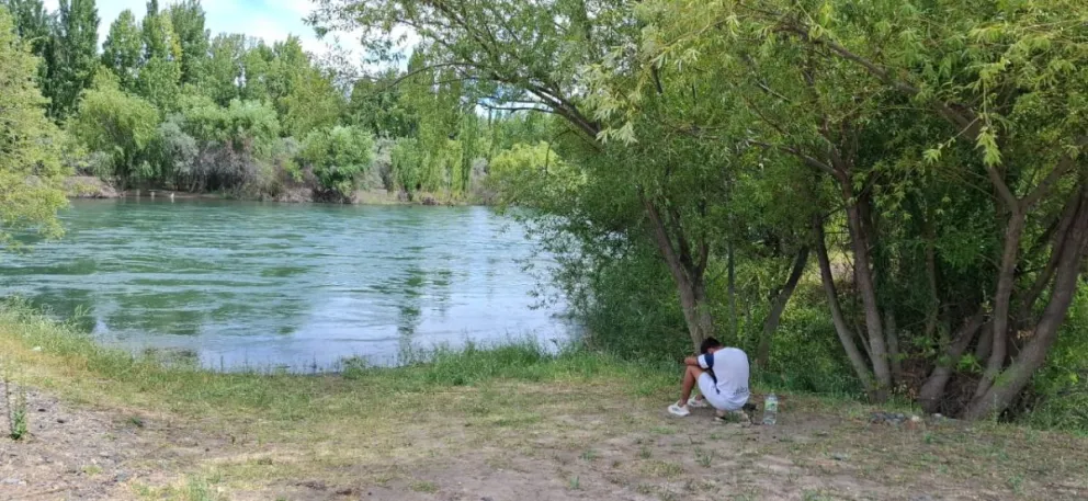 Continúa la búsqueda del hombre que fue arrastrado por el río Neuquén, mientras su hijo espera en la orilla. | Foto (Daniela Luján)