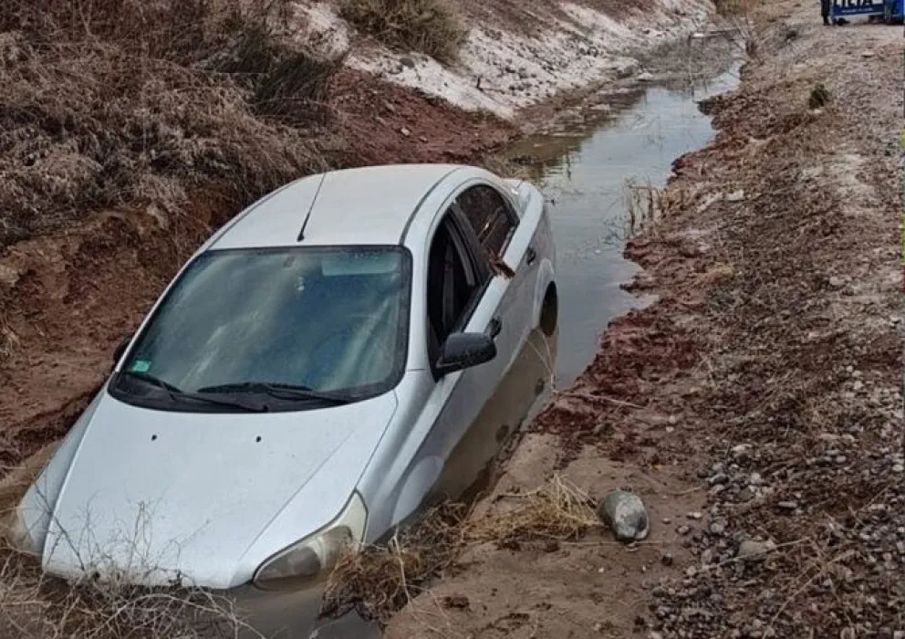 La joven conductora había quedado atrapada en el interior, ya que las puertas estaban trabadas entre el barro y la pared del desagüe. Foto: gentileza Centenario Digital.