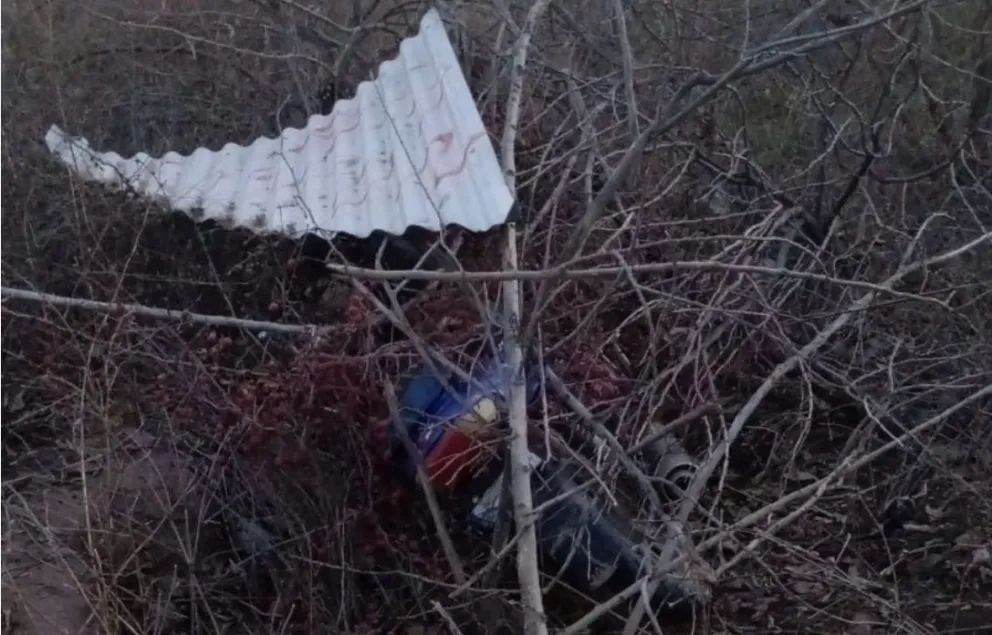 La moto había sido ocultada en una acequia, parcialmente cubierta por malezas y una chapa. Foto: Policía de Río Negro.