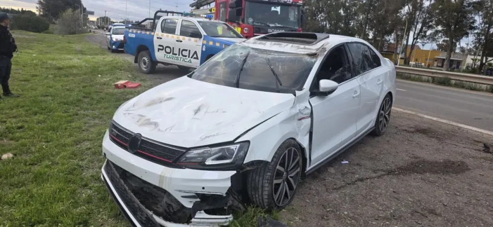 El VW Vento se pasó de largo en la rotonda y terminó volcando sobre la calzada de la ruta 7. El siniestro se produjo esta madrugada. Foto: gentileza Centenario Digital.